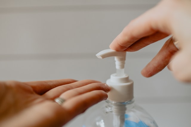 person putting hand sanitizer with 70% isopropyl alcohol in hand