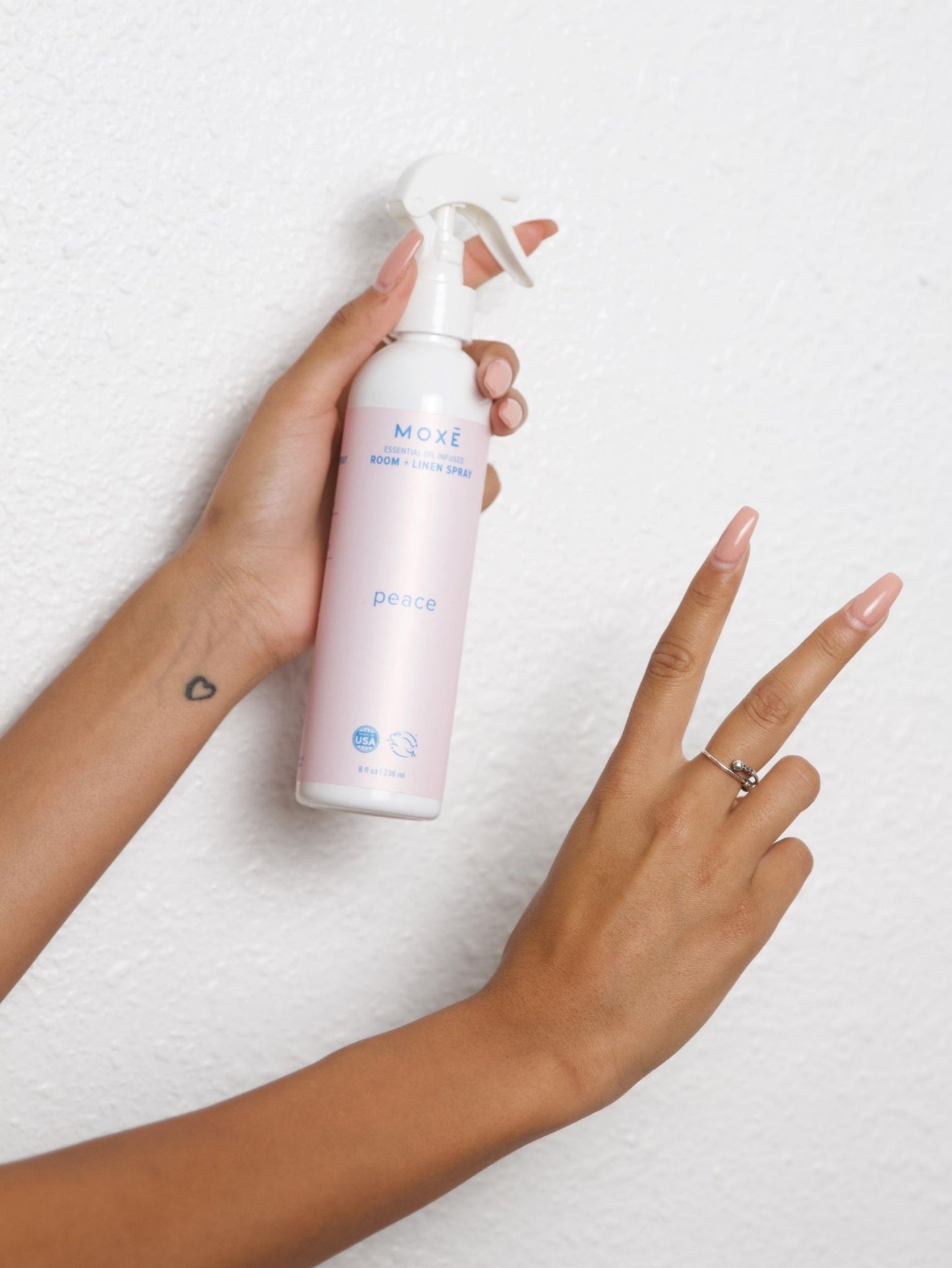 Girl Holding MOXĒ Peace Room + Linen Spray With Peace