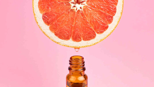 Fresh grapefruit juice being poured from above into an essential oil bottle