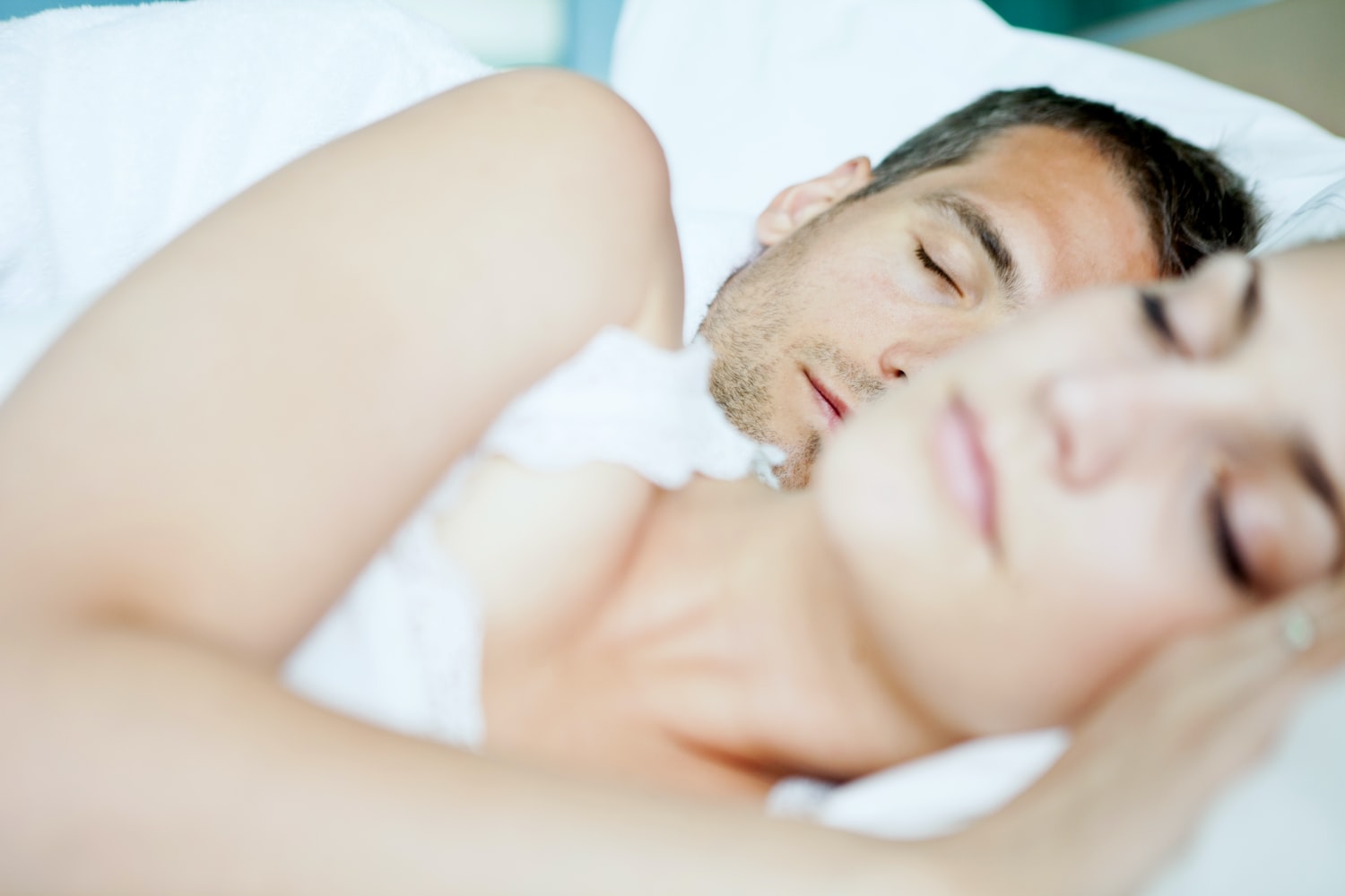 Man and women lying in bed spooning