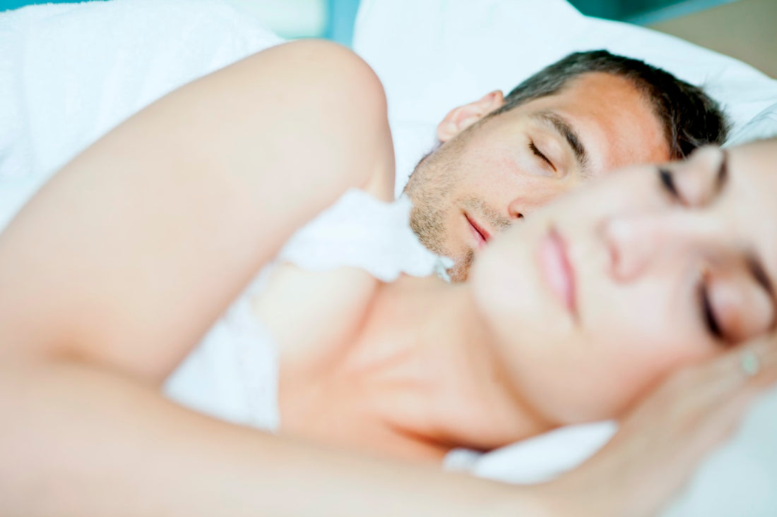 Man and women lying in bed spooning