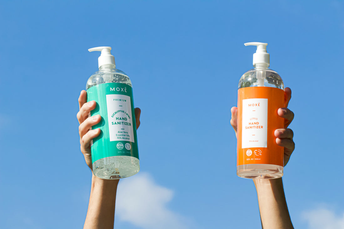 Holding MOXE Citrus Hand Sanitizer and Eucalyptus Mint Hand Sanitizer 