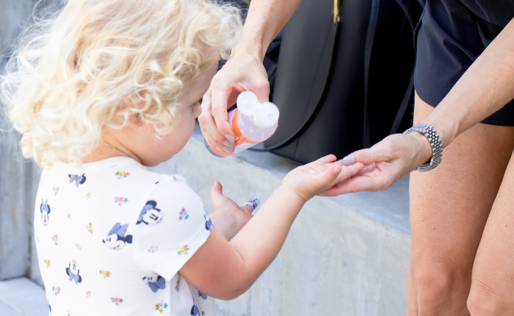 Mom using MOXE unscented hand sanitizer for children