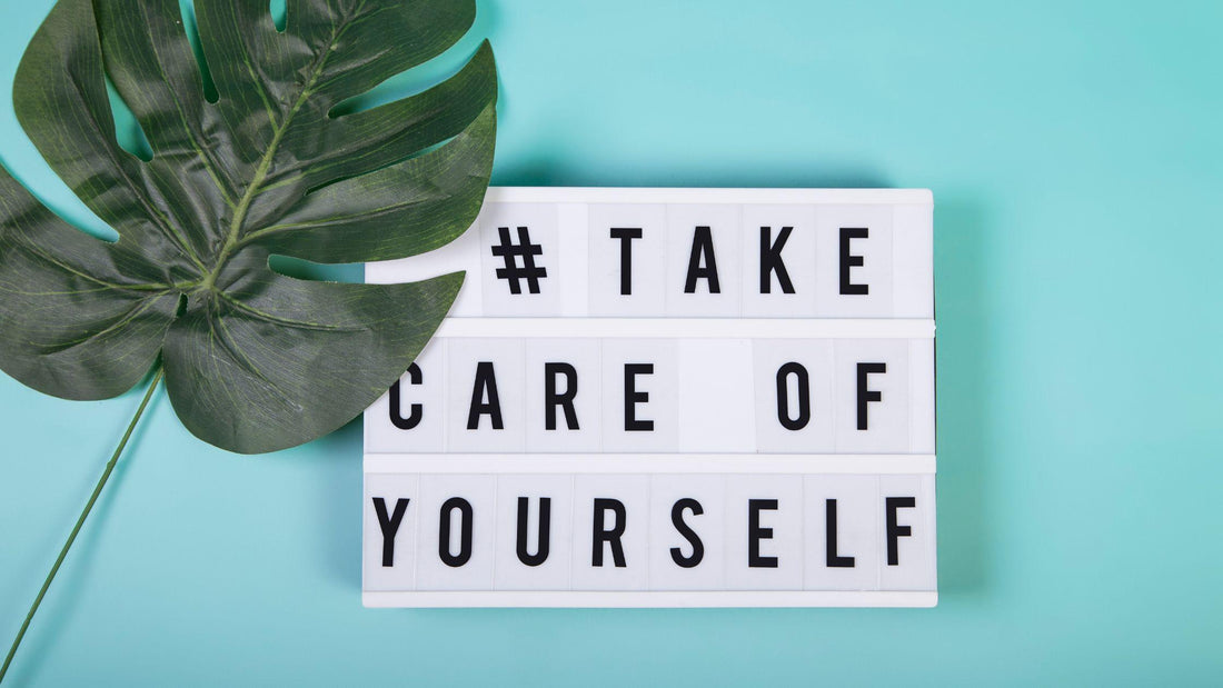 Sign that says #take care of yourself with palm leaf laying on it