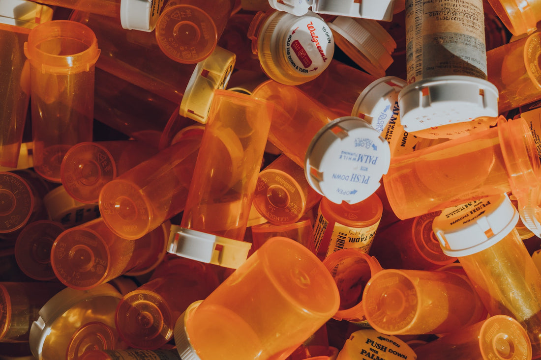 Collection of orange transparent pill bottles open and closed with white lids