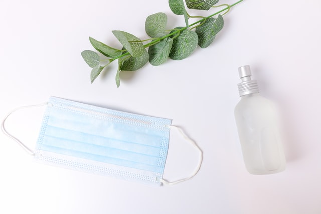 woman using premium hand sanitizer with essential oils on man to kill bacteria and prevent infection