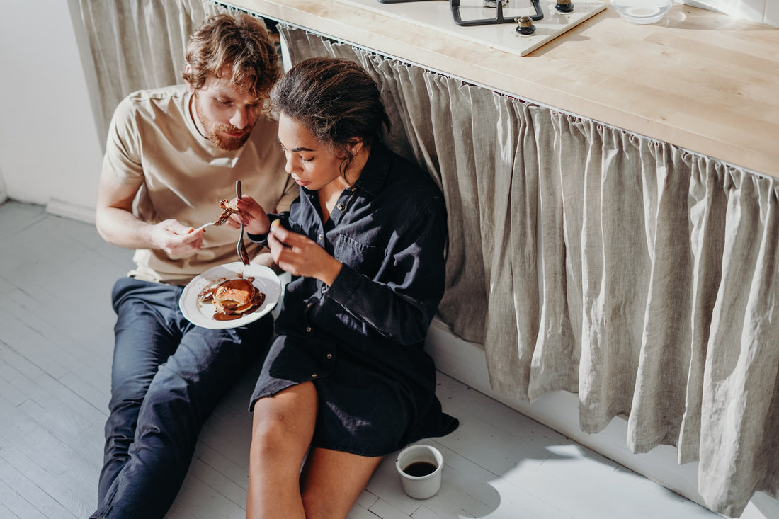 Man and women sitting on floor eating food