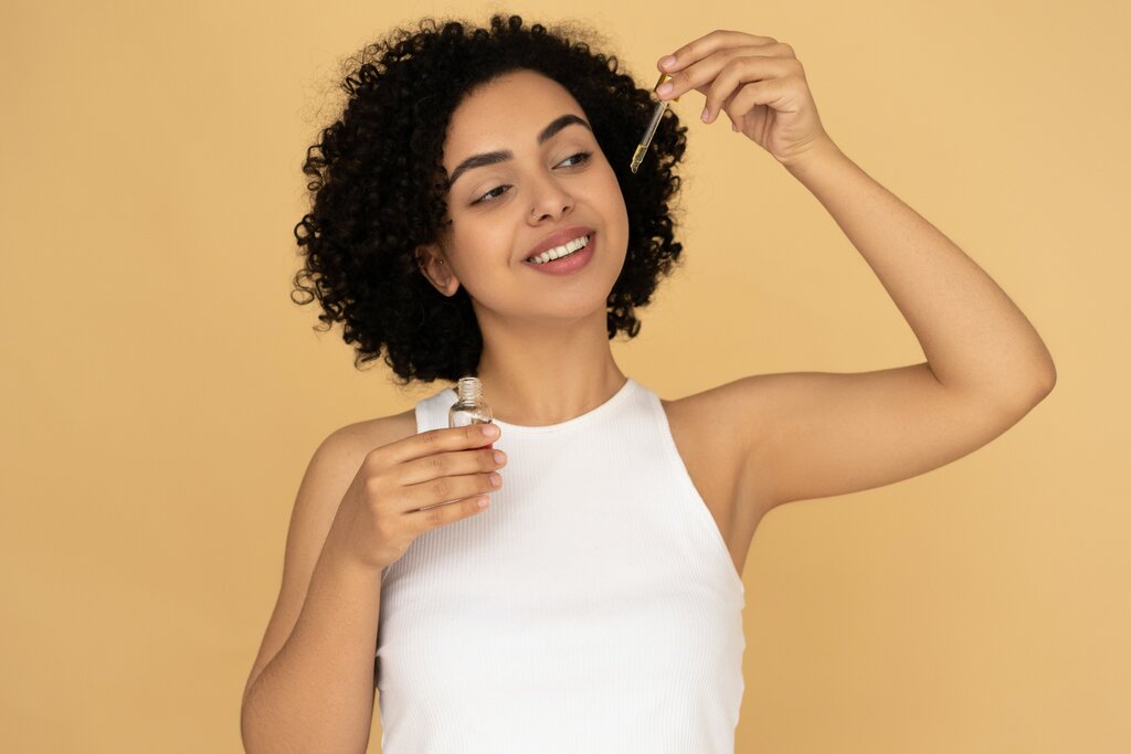 woman holding a bottle of essential oil