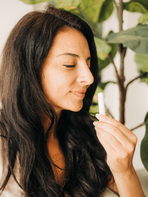 Woman smelling a MOXĒ Bergamot Aromatherapy Nasal Inhaler 