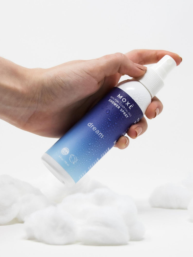 MOXĒ Dream Shower Spray with a hand holding it