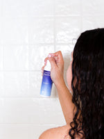 White bottle of MOXĒ Dream Shower Spray with blue label