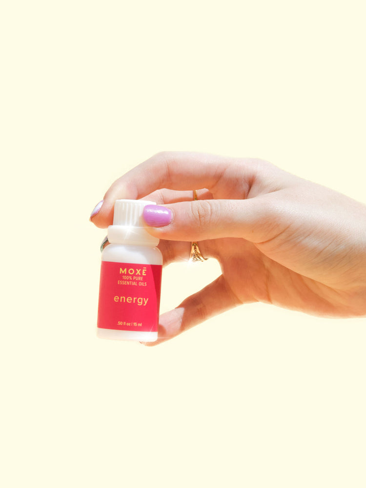 
                
                    Load image into Gallery viewer, MOXĒ Energy Essential Oil with a hand holding it
                
            