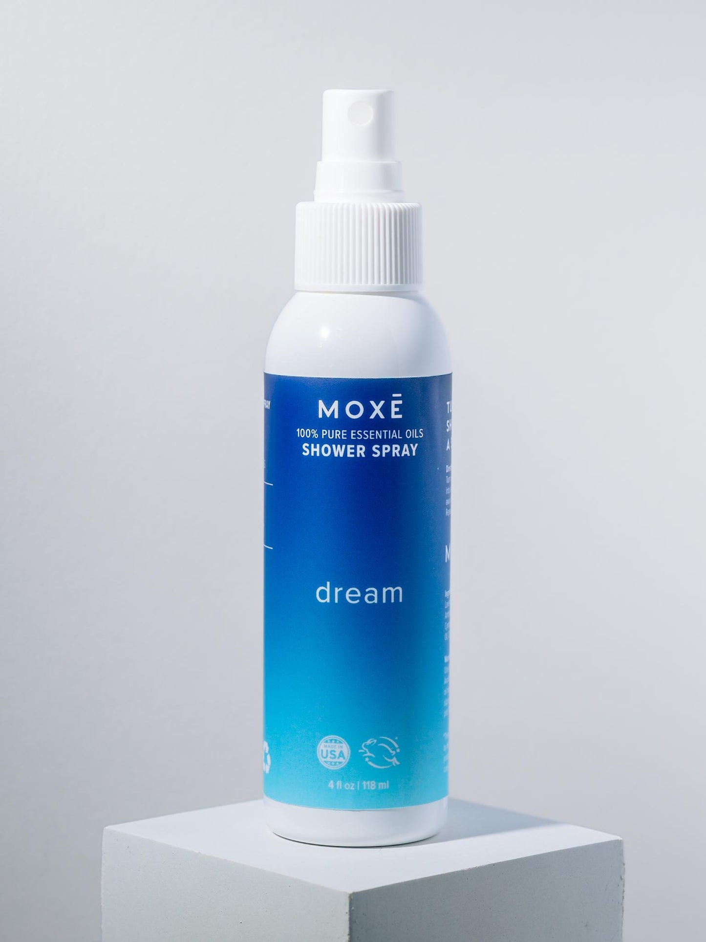 White bottle of MOXĒ Dream Shower Spray with blue label