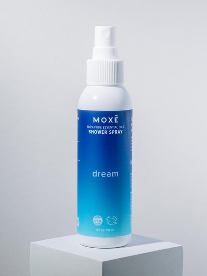 White bottle of MOXĒ Dream Shower Spray with blue label